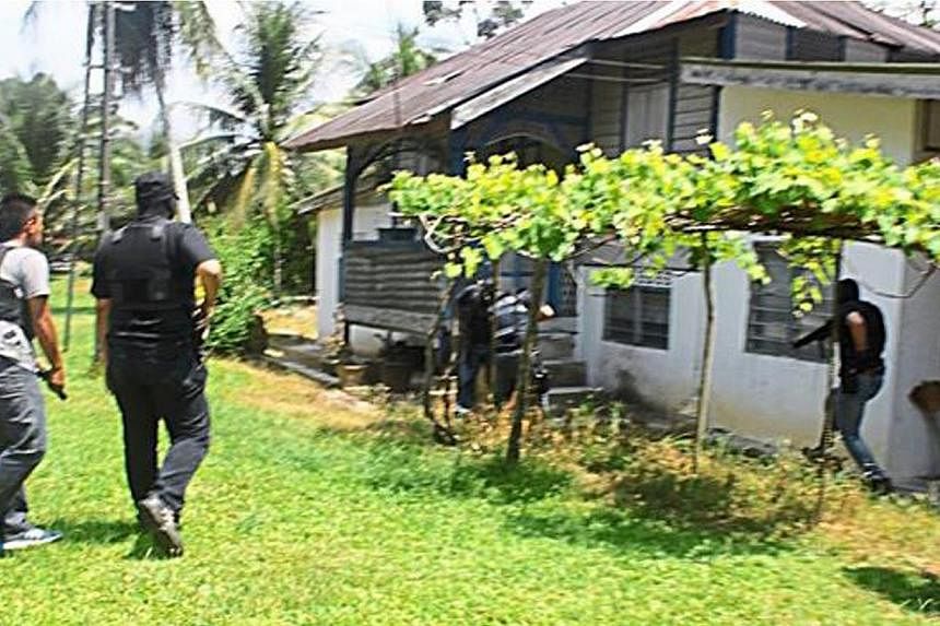 Bukit Aman’s Special Branch Counter Terrorism Division raiding a house in Kuala Kangsar, Perak, on June 18, 2014. -- PHOTO: THE STAR/ASIA NEWS NETWORK
