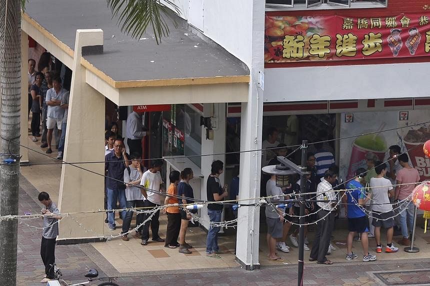 The queue for this year's $12-million jackpot has already started, with snaking queues at hotspot 7-Eleven outlet of Block 102 Yishun Avenue 5 on Thursday. -- PHOTO: ST FILE