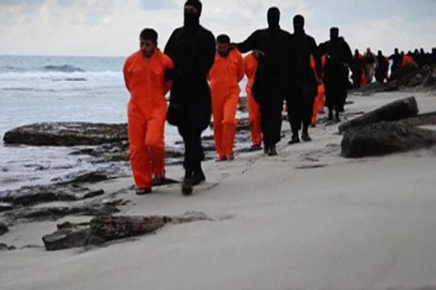 Egyptian Christians held captive by ISIS being marched along a beach - thought to be near Tripoli, Libya - before they were beheaded. This still image from an undated video was made available on social media on Feb 15.