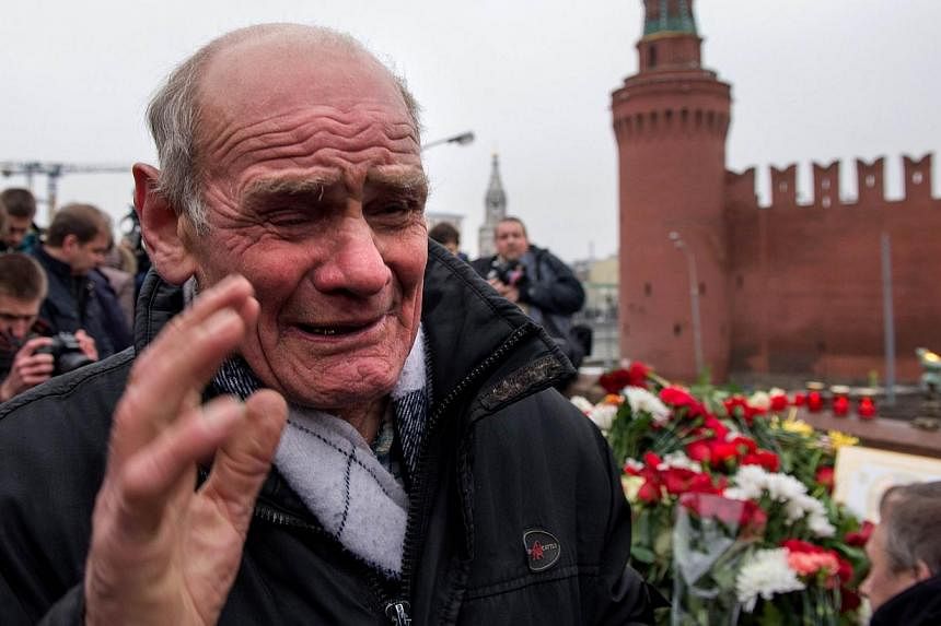 A man cries at the spot, where Russian opposition leader Boris Nemtsov was shot dead, near Saint-Basil's Cathedral, in the centre of Moscow on Feb 28, 2015. Russian President Vladimir Putin promised the mother of Nemtsov on Saturday that everything w