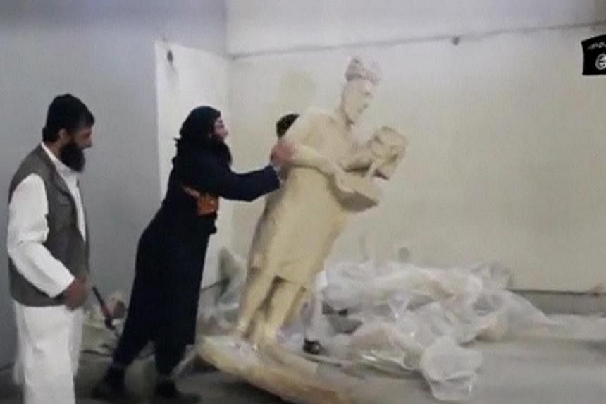 A man topples a statue in a museum at a location said to be Mosul in this still image taken from an undated video. Islamic State in Iraq and Syria (ISIS) militants who destroyed priceless antiquities from the northern Iraqi city of Mosul have kept so