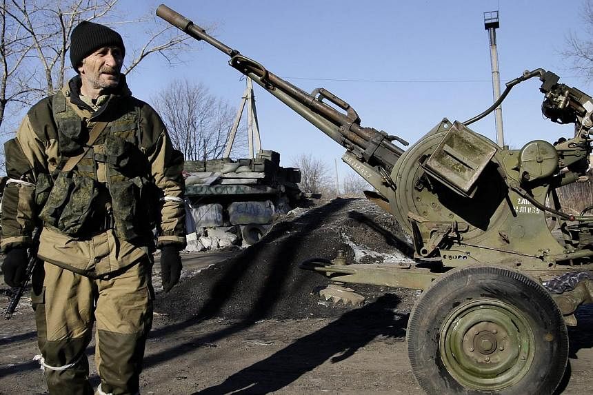 A pro-Russian rebel walks past a twin-barrelled anti-aircraft gun in the streets of Debaltseve, in the Donetsk area of Ukraine on Feb 21, 2015. Spain on Friday arrested eight citizens who recently returned from fighting alongside pro-Russian rebels i