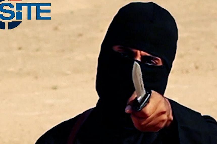 A masked, black-clad militant, who has been identified by the Washington Post newspaper as a Briton named Mohammed Emwazi, brandishes a knife in this still image from a 2014 video obtained from SITE Intel Group on Feb 26, 2015. -- PHOTO: REUTERS