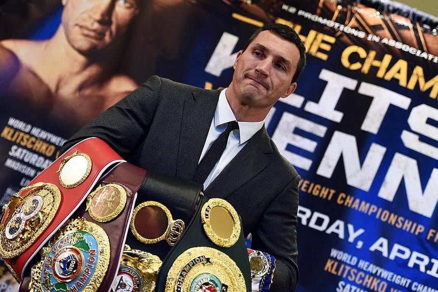 World Heavyweight boxing champion Wladimir Klitschko of Ukraine holds his belts before posing with US challenger Bryant Jennings during a news conference at the Madison Square Garden in New York on Feb 4, 2015. -- PHOTO: AFP