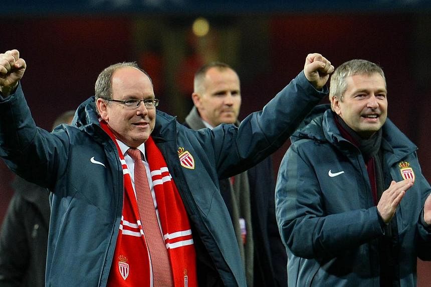 Prince Albert II of Monaco (left) celebrates on the field with Monaco's Russian president Dmitry Rybolovlev (right) after the final whistle of the UEFA Champions League round of 16 first leg football match between Arsenal and Monaco at the Emirates S
