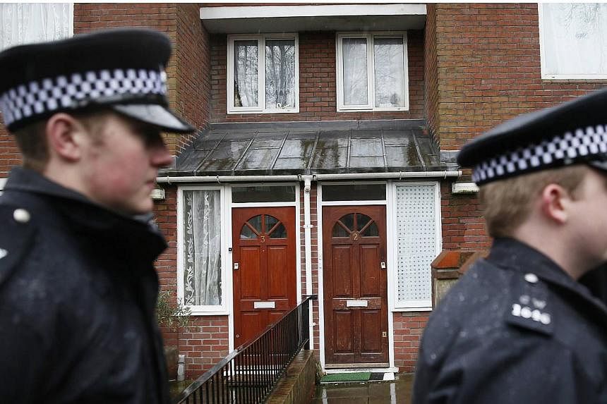 Two police officers walk outside a flat in London on 26 Feb, 2015.&nbsp;Kuwaiti authorities are closely monitoring several relatives of "Jihadi John" who live and work in the Gulf emirate where the Islamic State in Iraq and Syria (ISIS) executioner w