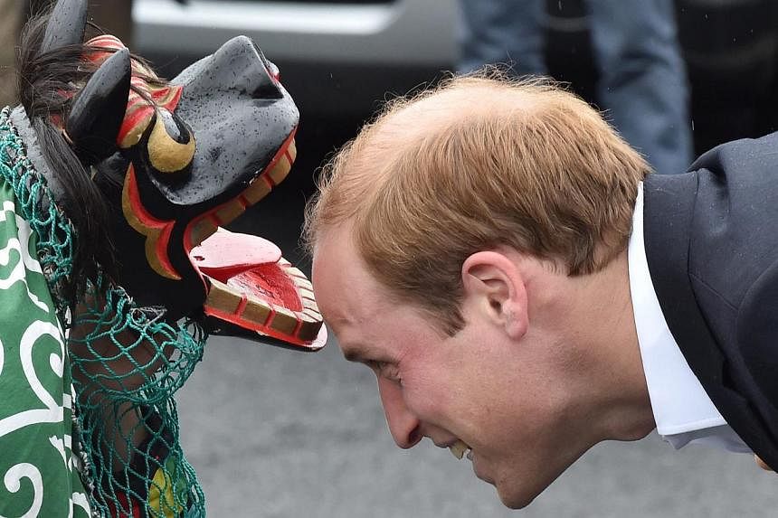 Britain's Prince William (right) being greeted by a lion dancer during his visit to the Chime of Hope Shopping Centre in Onagawa, Miyagi prefecture, Japan, on March 1, 2015. -- PHOTO: EPA