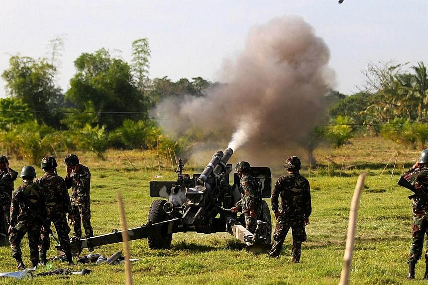 In this photo taken on Feb 28, 2015, government forces of the 6th Infantry Division fire a105 Howitzer canon in Maguindanao, Southern Philippines.&nbsp;The Philippine military is trying to capture a bombmaker it believes is being "coddled" by Filipin