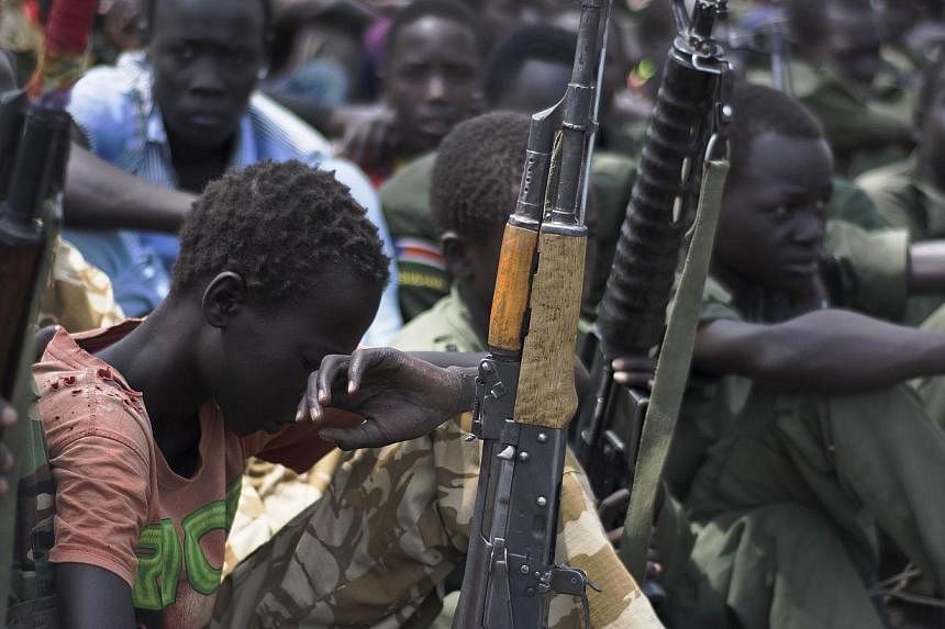 Child soldiers sitting on with their rifles at a ceremony of the child soldiers disarmament, demobilisation and reintegration in Pibor, South Sudan overseen by UNICEF and partners on Feb 10, 2015.&nbsp;The UN children's agency said on Sunday, March 1