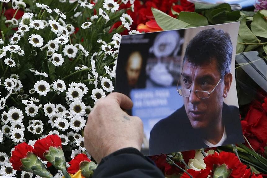 A visitor holds a photo at the site where Boris Nemtsov was recently murdered, in central Moscow, Feb 28, 2015.&nbsp;Nemtsov had enemies politically and personally. Even among the opposition, his outsized character pulled some into his orbit and push