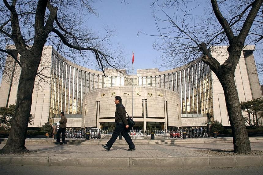 People walking past the People's Bank of China in Beijing, China, on Jan 8, 2008. China's central bank cut benchmark interest rates for the second time in three months as disinflation gives room to step up support for the nation's slowing economy. --