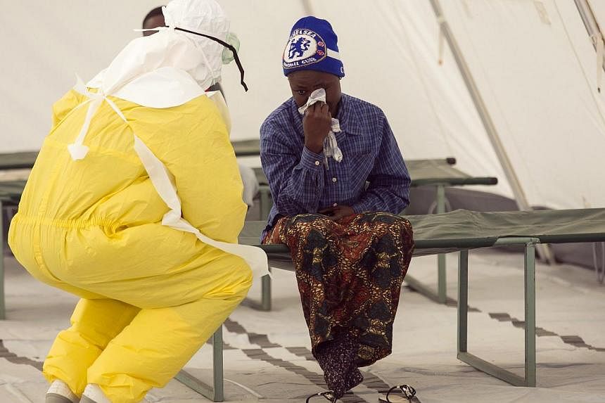 A health worker wearing protective gear attends to a newly admitted suspected Ebola patient in a quarantine zone at a Red Cross facility in the town of Koidu, in Eastern Sierra Leone in this Dec 19, 2014 file photo. -- PHOTO: REUTERS