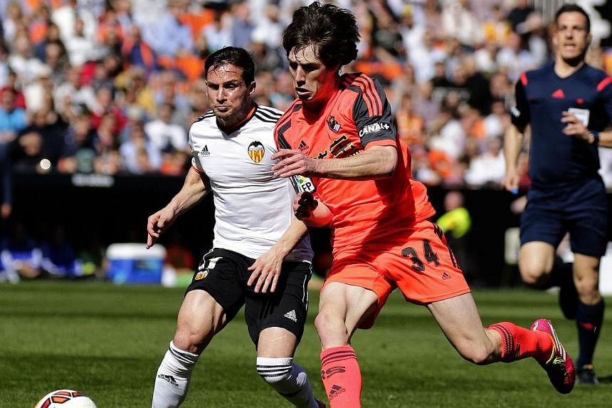 Valencia's Argentinian forward Pablo Piatti (left) vies with Real Sociedad's defender Julen Etxabeguren during the Spanish league football match Valencia CF vs Real Sociedad de Futbol at the Mestalla stadium in Valencia on March 1, 2015. -- PHOTO: AF