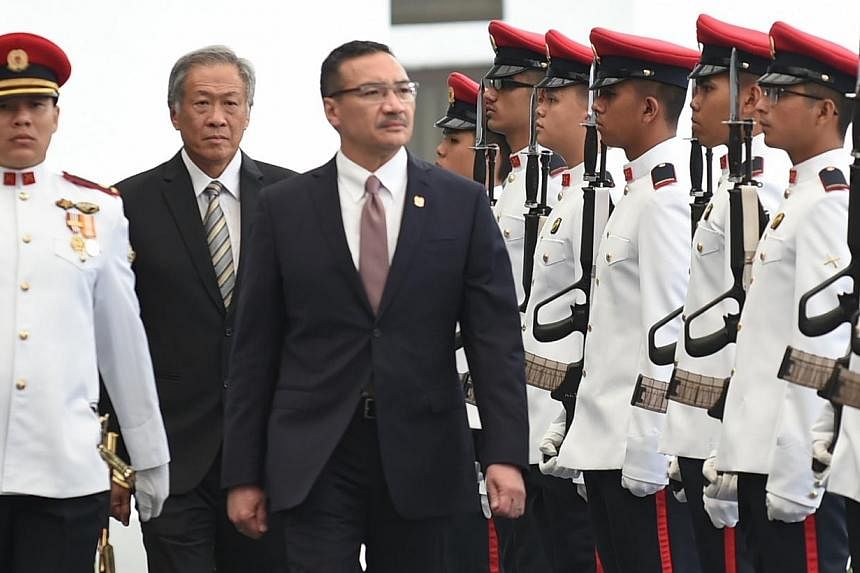 Malaysian Minister for Defence Hishammuddin Hussein (centre), accompanied by Singapore Defence Minister Ng Eng Hen (second from left), inspecting the Guard of Honour at the Ministry of Defence on March 2, 2015. -- PHOTO: MINDEF