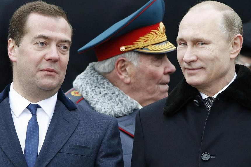 Russian President Vladimir Putin (right) and Prime Minister Dmitry Medvedev attend a wreath-laying ceremony to mark the Defender of the Fatherland Day at the Tomb of the Unknown Soldier by the Kremlin walls in central Moscow on Feb 23, 2015. -- PHOTO