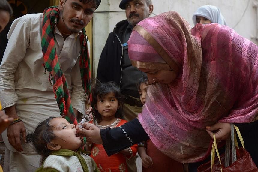 A Pakistani health worker administers polio drops to a child during a polio vaccination campaign in Karachi on Jan 20, 2015. Pakistani police arrested 471 parents who refused the vaccine, said the deputy police commissioner of Peshawar on Monday, Mar