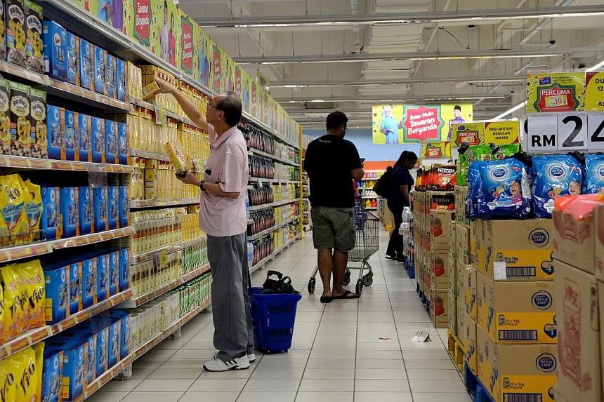 People buying groceries at Tesco in Johor Bahru’s KSL City. Major supermarkets in Malaysia will be slashing prices up to 70 per cent for more than 82,000 products as part of a new national price reduction campaign. -- PHOTO: ST FILE