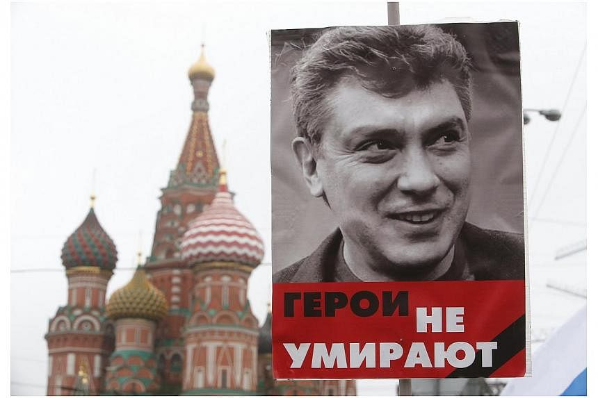 A poster of Kremlin critic Boris Nemtsov, who was shot dead on Friday night, is seen during a march to commemorate him near St Basil's Cathedral in central Moscow on March 1, 2015. -- PHOTO: REUTERS