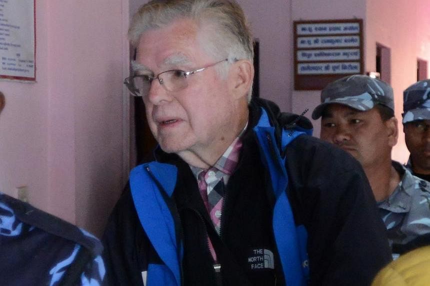 Canadian national Ernest Fenwick MacIntosh, convicted of sexually abusing a Nepalese child on Sunday is escorted by police for his appearance at the District Court in Lalitpur in a suburb of Kathmandu. -- PHOTO: AFP&nbsp;