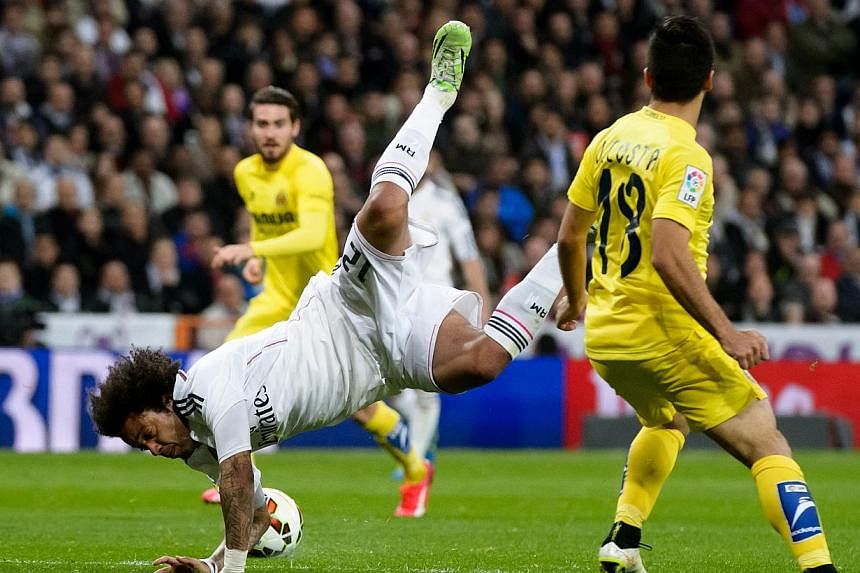 Real Madrid's Brazilian defender Marcelo (left) vies with Villarreal's defender Jaume Costa during the Spanish league football match Real Madrid CF vs Villarreal CF at the Santiago Bernabeu stadium in Madrid on Sunday. -- PHOTO: AFP&nbsp;