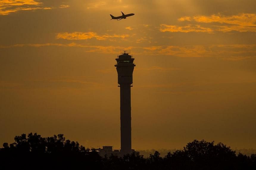 A plane flying past a control tower at Kuala Lumpur International Airport (KLIA). -- PHOTO: AFP