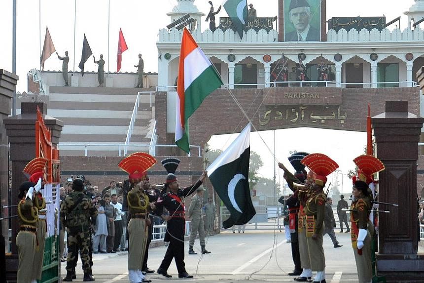 Pakistani Rangers (in black) and Indian Border Security Force personnel (in khaki) performing the flag-off ceremony during India's 66th Republic Day at the India-Pakistan Wagah Border Post on Jan 26, 2015. -- PHOTO: AFP