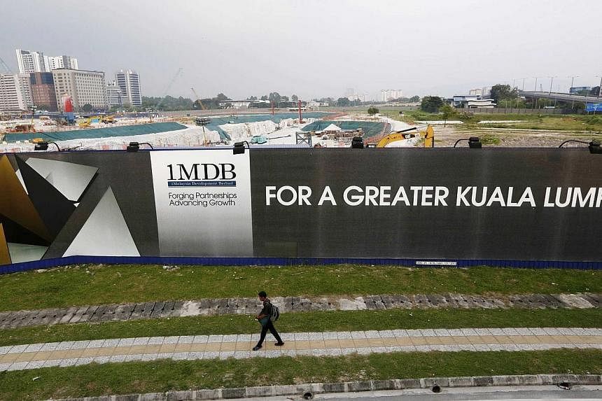A man walks past a 1 Malaysia Development Berhad (1MDB) billboard at the funds flagship Tun Razak Exchange development in Kuala Lumpur on March 1, 2015. -- PHOTO: REUTERS