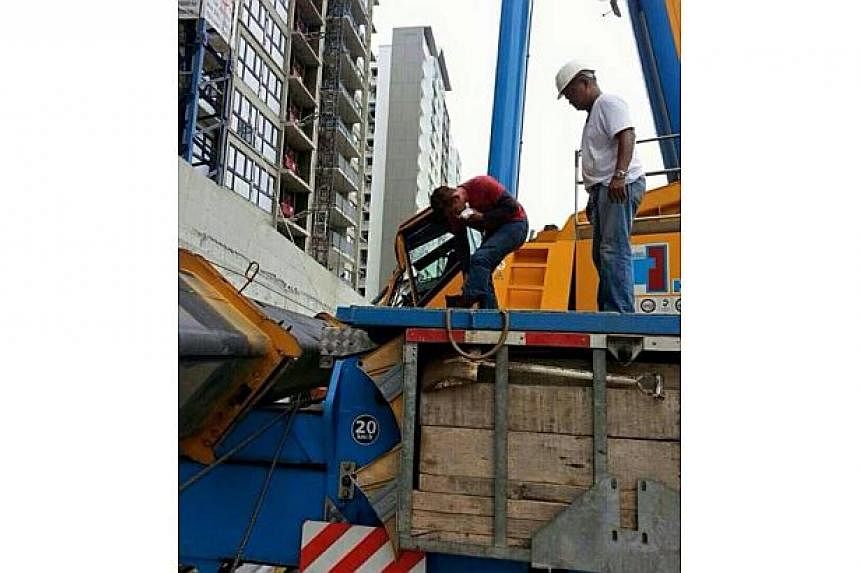 A crane at a construction site of an upcoming executive condominium in Punggol toppled over on Tuesday. -- PHOTO: ST READER&nbsp;