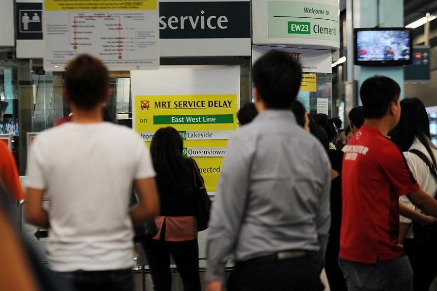 Passengers at Clementi MRT station looking at a sign indicating a train delay on the East-West line during the evening rush hour on March 3, 2015. -- ST PHOTO: TIFFANY GOH&nbsp;