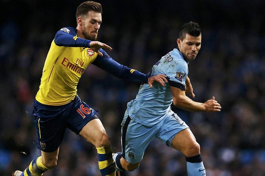Arsenal's Aaron Ramsey (left) challenges Manchester City's Sergio Aguero during their English Premier League soccer match at the Etihad stadium in Manchester, northern England Jan 18, 2015. -- PHOTO: REUTERS