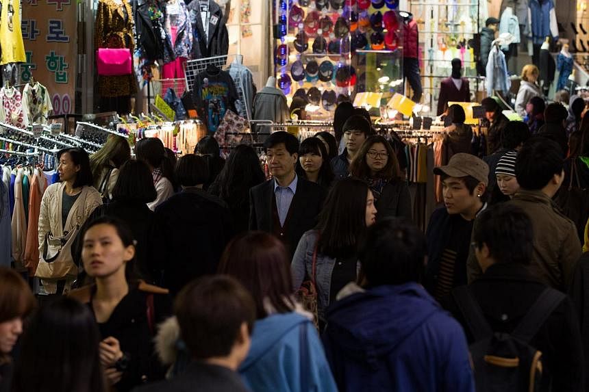 People walk through the Hongdae shopping district at night in Seoul, South Korea. The country's inflation hit its lowest level in more than 15 years in February owing to slumping oil prices, state data showed Tuesday, fuelling concerns about deflatio