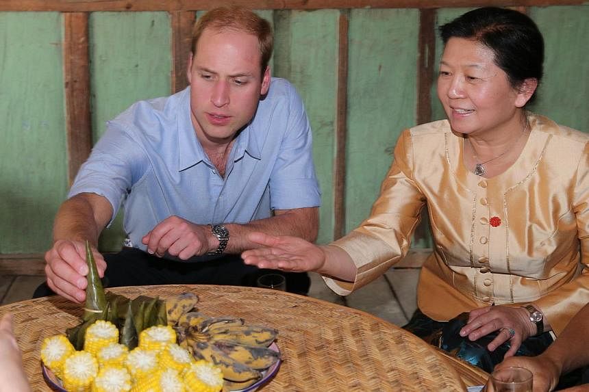 Britain's Prince William (left) visits a local villager's home in Xishuangbanna, or Sibsongbanna Dai autonomous prefecture, south-west China's Yunnan province on March 4, 2015. -- PHOTO: AFP