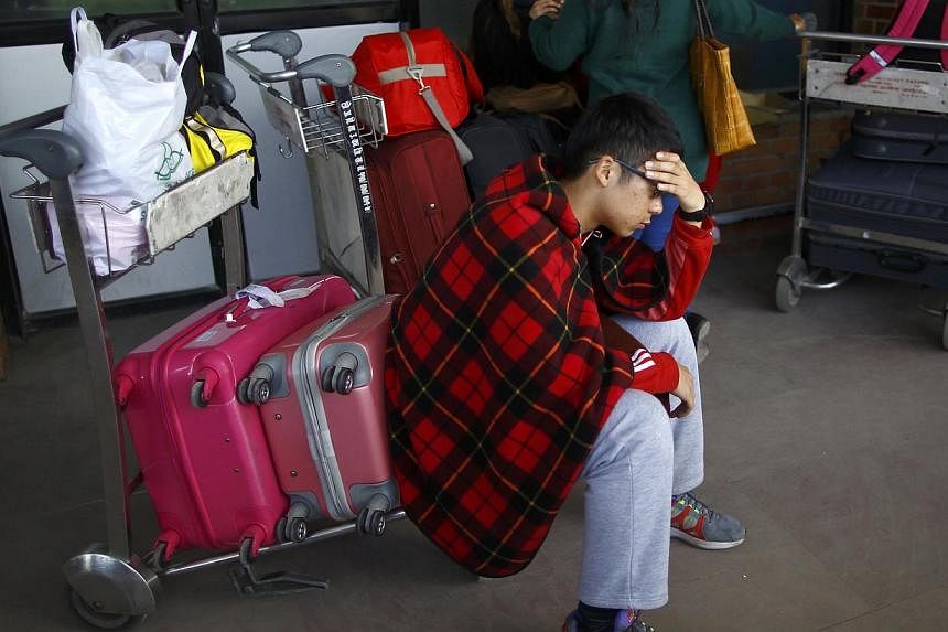 A stranded passenger waits at Tribhuvan International Airport following the airport's closure after a Turkish Airlines plane overshot a runway in Kathmandu on March 4, 2015. -- PHOTO: REUTERS