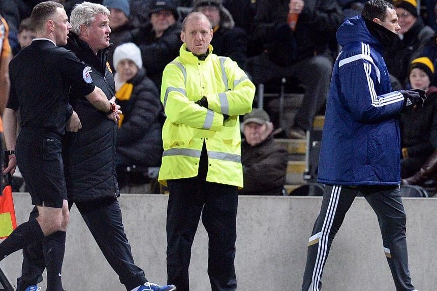 Hull City's English manager Steve Bruce (second from left) is held back as Sunderland's Uruguayan manager Gus Poyet (right) is sent to the stands on Mar 3, 2015. -- PHOTO: AFP&nbsp;