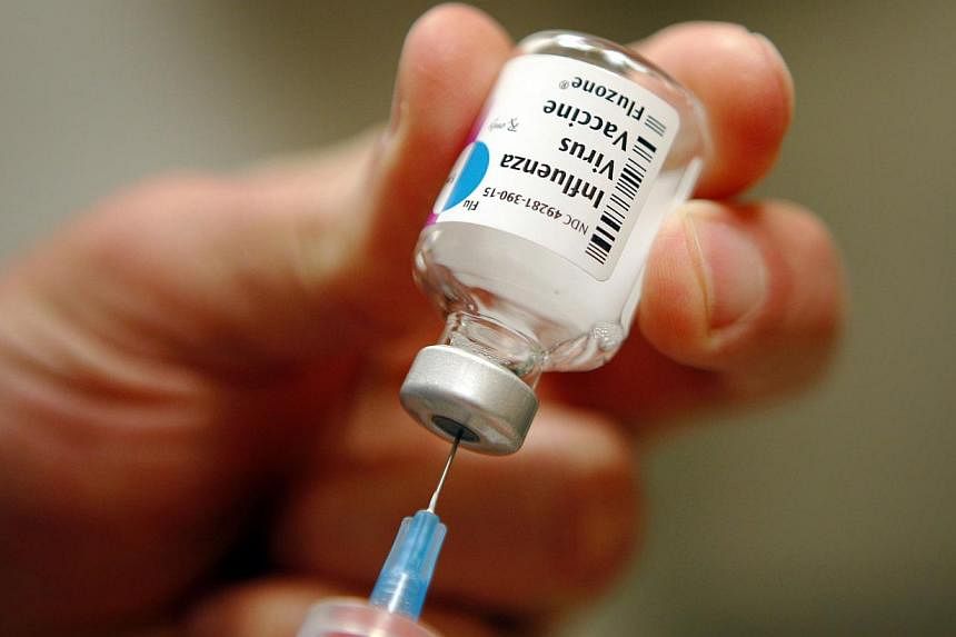 A nurse preparing an injection of the influenza vaccine at Massachusetts General Hospital in Boston, Massachusetts on Jan 10, 2013.&nbsp;Scientists have found that adults only get flu twice a decade on average. -- PHOTO: REUTERS