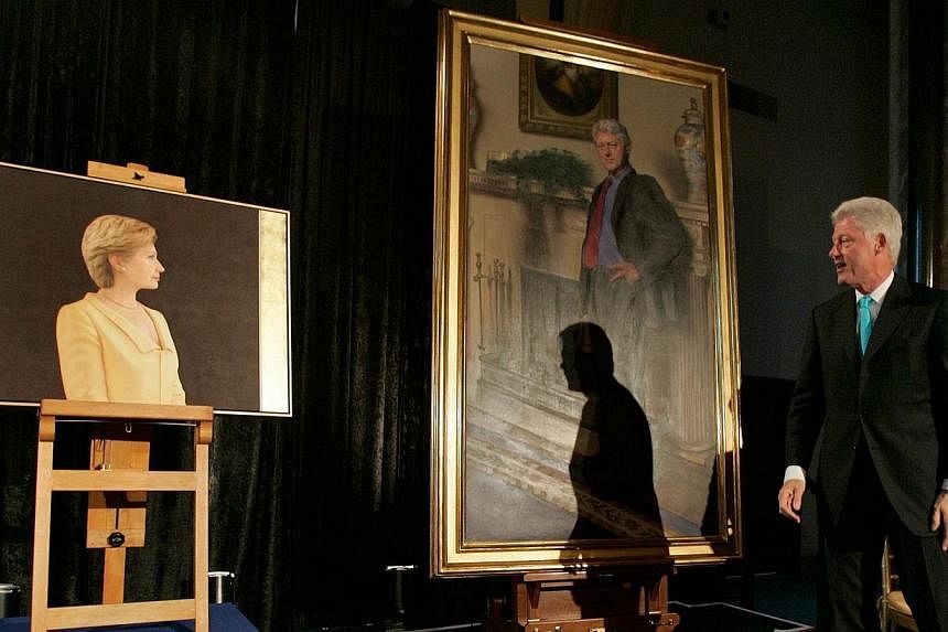 This April 24, 2006 file photo shows former US President Bill Clinton looking at his and his wife Hillary Clinton's portraits during an unveiling ceremony at the Smithsonian in Washington, DC. Mr Clinton's portrait, now in the National Portrait Galle