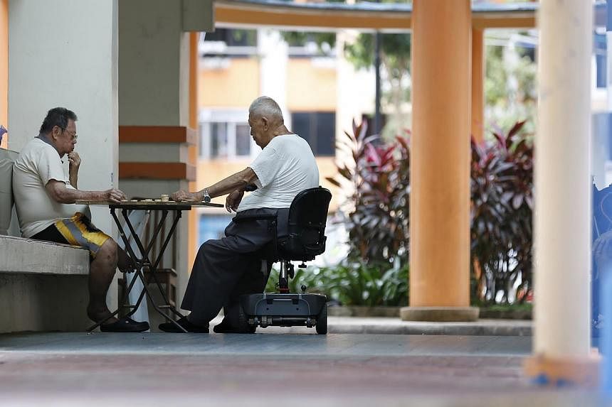 Two elderly man playing Chinese chess at a HDB block on Feb 23, 2015. During the first day of debate on Budget 2015, most MPs welcomed the largesse of new programmes such as the Silver Support Scheme to give the poorest elderly a basic pension. -- PH