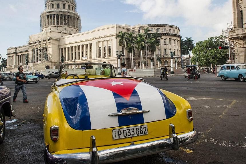 An old car with the Cuban flag painted on its trunk is seen near the Capitol of Havana, on Jan 7, 2015. -- PHOTO: AFP