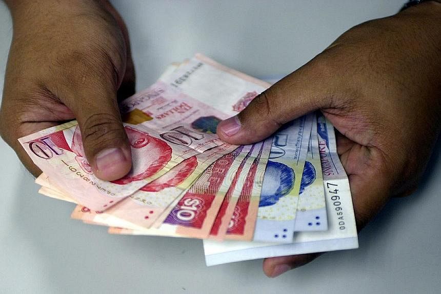 The Singdollar's low ebb comes amid market talk that the central bank here will next month move to allow the local currency to soften further to give a lift to manufacturers, as the inflation threat recedes. -- PHOTO: ST FILE