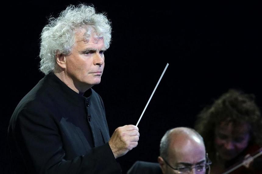 Rattle conducting the London Philharmonic Orchestra during the Opening Ceremony of the London 2012 Olympic Games at the Olympic Stadium in London, Britain. He is leaving the Berlin Philharmonic to lead the London Symphony Orchestra. -- PHOTO: EPA
