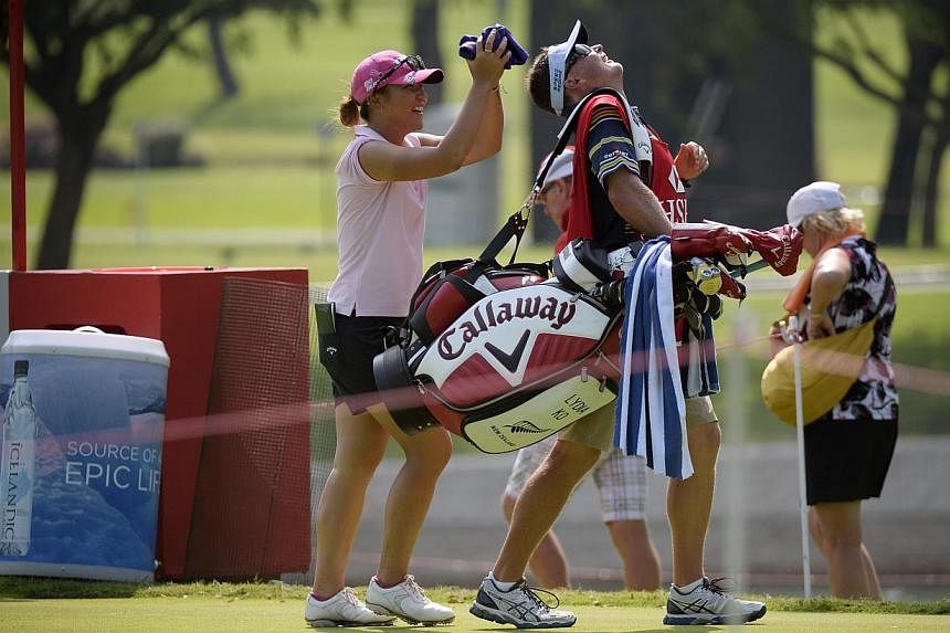 Lydia Ko of New Zealand jokes with her caddie after teeing off at the 11th hole during the Pro-am event on the eve of the HSBC Women's Champions on March 4, 2015. -- ST PHOTO: MARK CHEONG