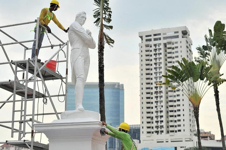 The statue of Sir Stamford Raffles being cleaned in 2014. Barricades and hoardings will soon be erected around several statues and landmarks along the Singapore River, to protect them from construction works. -- PHOTO: ST FILE&nbsp;