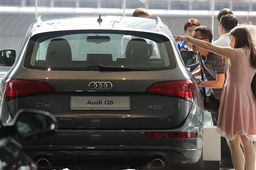 People looking at a car in the Audi showroom at Alexandra Road. COE&nbsp;premiums ended mostly higher in the latest tender on Wednesday, March 4, 2015.&nbsp;-- PHOTO: ST FILE