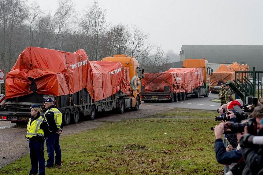 Lorries carrying the wreckage of the passenger airplane MH17 that crashed in Ukraine arrive at Gilze-Rijen airbase in the Netherlands on Dec 9 last year. -- PHOTO: AFP
