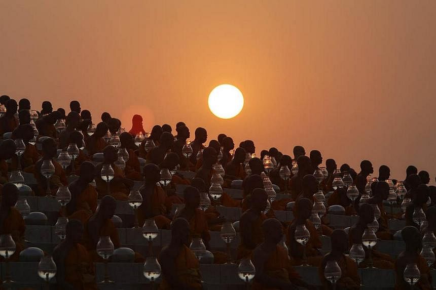 Buddhist monks prepare for an alms offering ceremony at the Wat Phra Dhammakaya temple in the north of Bangkok as the sun rises on Makha Bucha Day on March 4, 2015. -- PHOTO: REUTERS&nbsp;