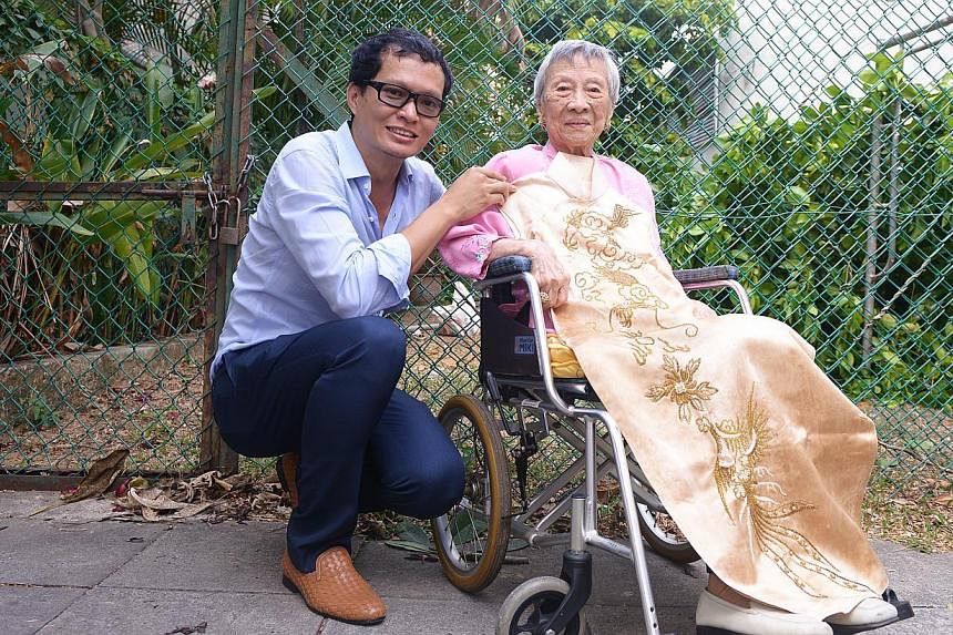 Artist-architect Randy Chan with Madam Maggie Kwek and her cheongsam dating back to the 1940s. -- ST PHOTO: DANIEL NEO