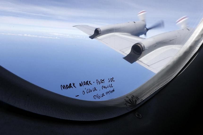 Hand-written notes on how a crew member should report the sighting of debris in the southern Indian Ocean is pictured on a window aboard a Royal New Zealand Air Force P-3K2 Orion aircraft searching for missing Malaysia Airlines Flight MH370. -- PHOTO