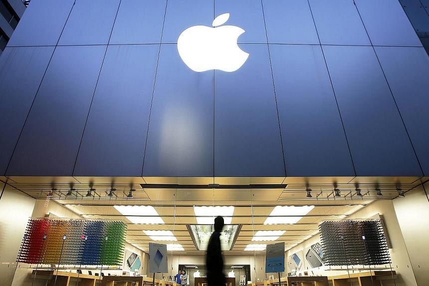 A man walks past an Apple store in the Ginza district of Tokyo, Japan. The company, which has seen stagnating iPad sales, will delay the start of manufacturing for a larger-screened version of the tablet. -- PHOTO: BLOOMBERG