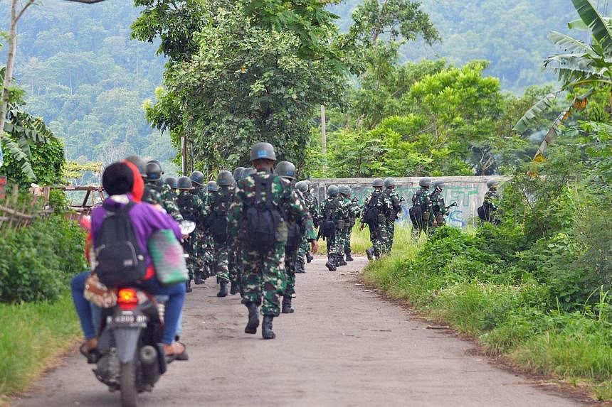 Indonesian military troops marching near Nusakambangan island (in the background) on March 5, 2015, where Australian death row inmates Andrew Chan and Myuran Sukumaran were transferred from Kerobokan prison in Bali. -- PHOTO: AFP