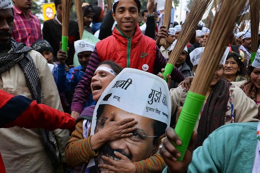 Voters in New Delhi showing their support for the Aam Aadmi Party in January. Party chief Arvind Kejriwal's picture is a favourite, but many carry a broom, the party's election symbol in the Delhi elections.
